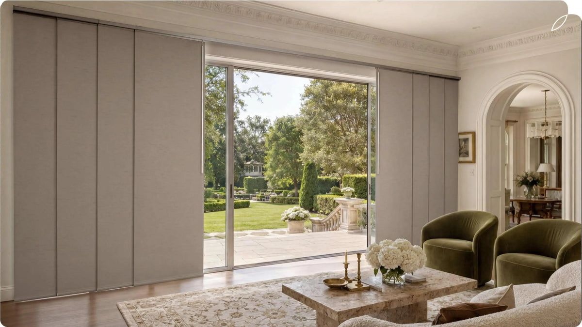 The living room is equipped with large Windows and manual panel track blinds