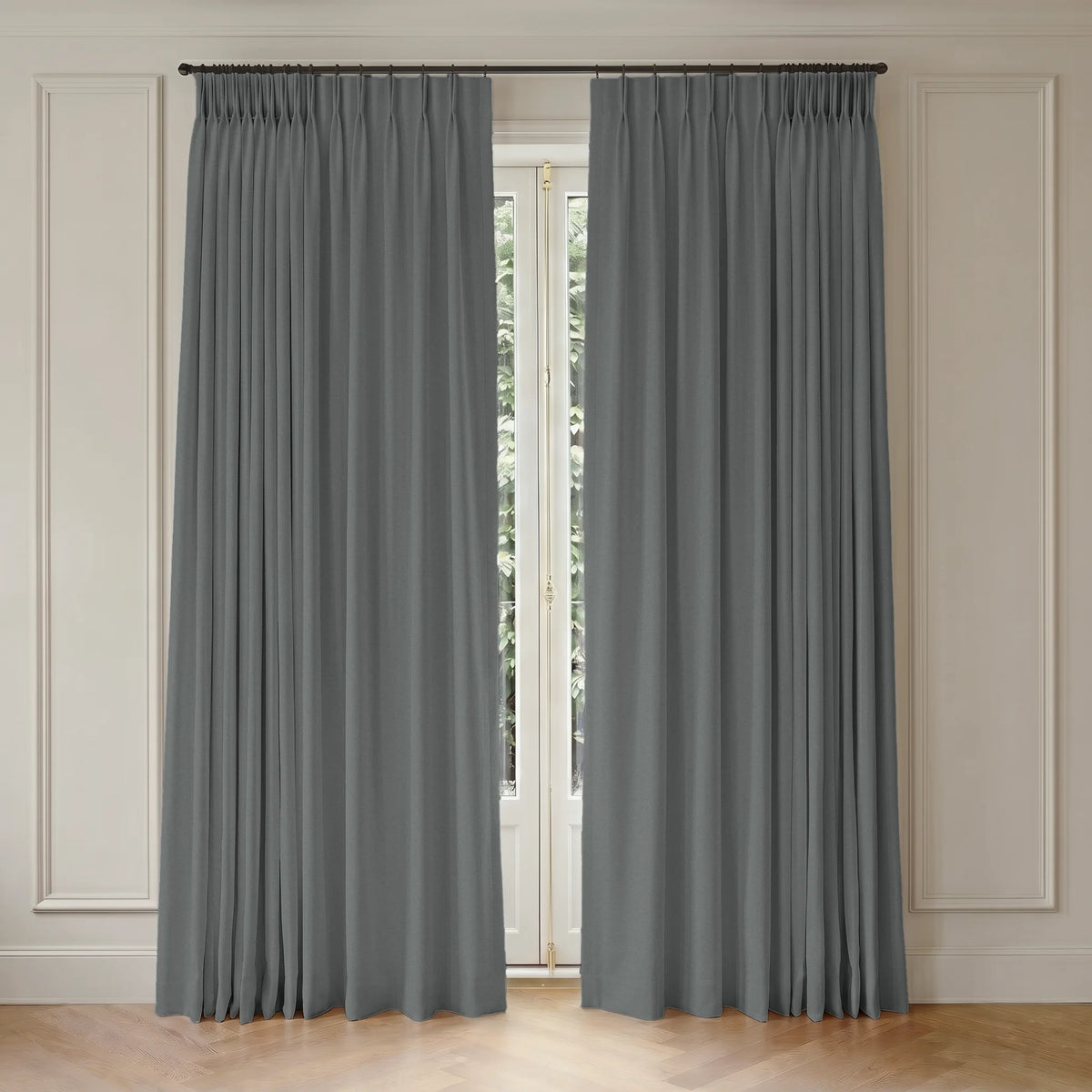Gray room darkening curtains hanging in front of a window with light-colored walls.