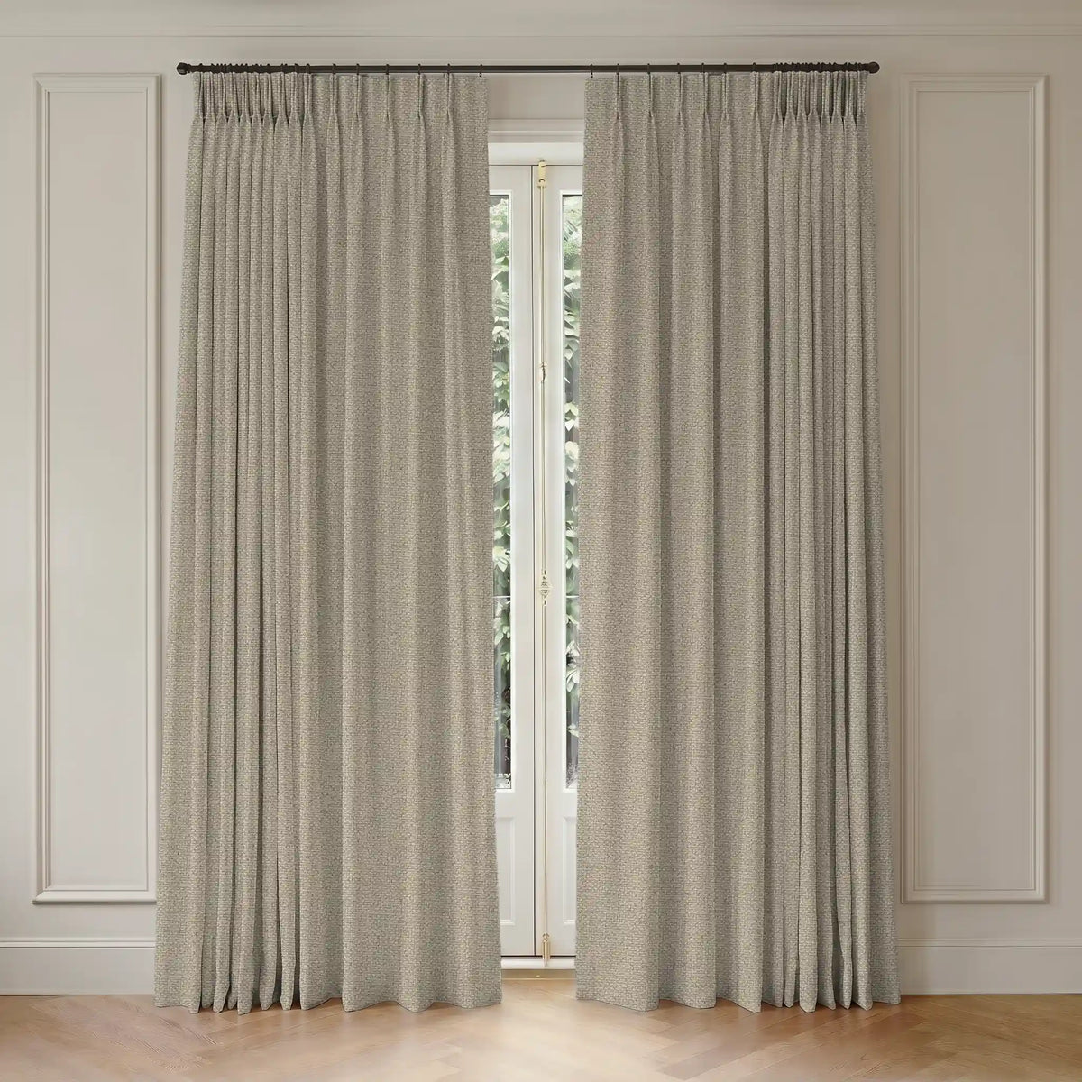 Pair of beige custom curtains hanging in front of a window with light-colored paneled walls.