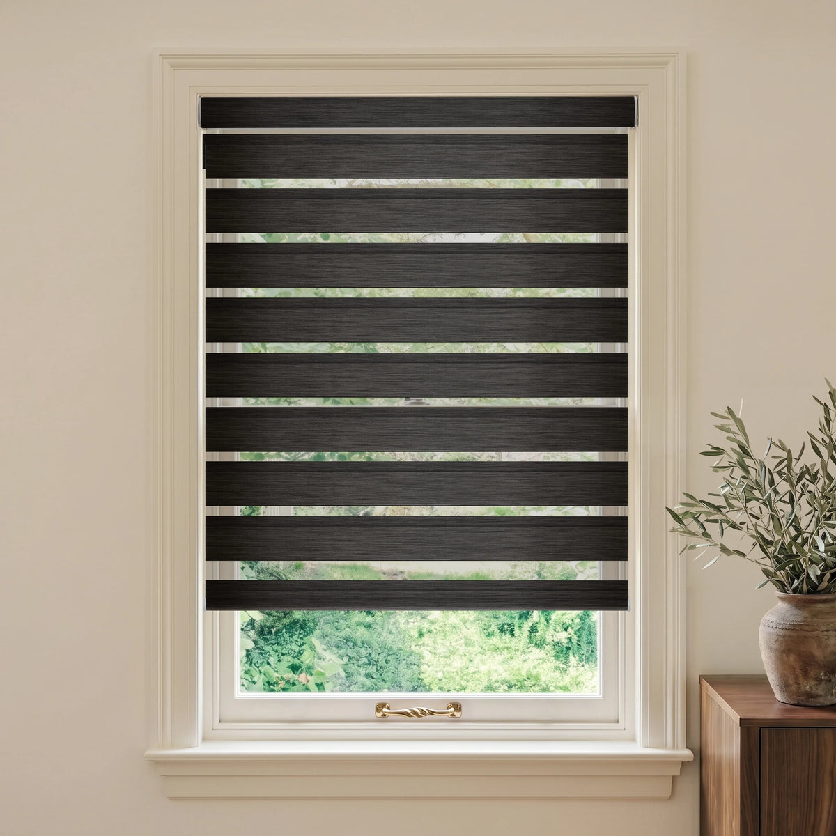 Charcoal motorized room-darkening zebra blind on a white-framed window in a neutral room.