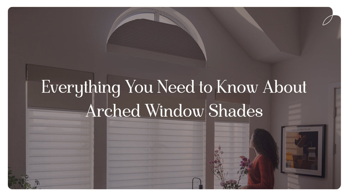 Living room with arched window shades, sunlight streaming in, person holding flowers.
