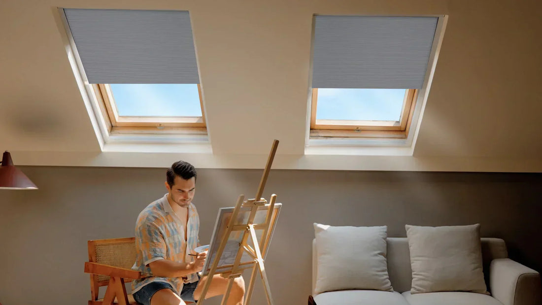 The attic scene, equipped with skylight shades, shows a man engaged in painting, with an intense artistic atmosphere.