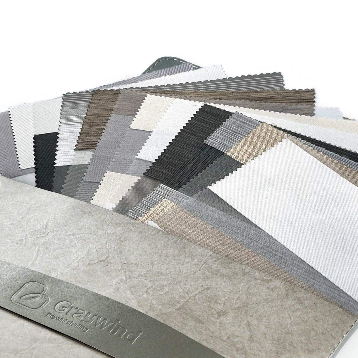 Assorted fabric swatches for custom window treatments in neutral tones on a display book.