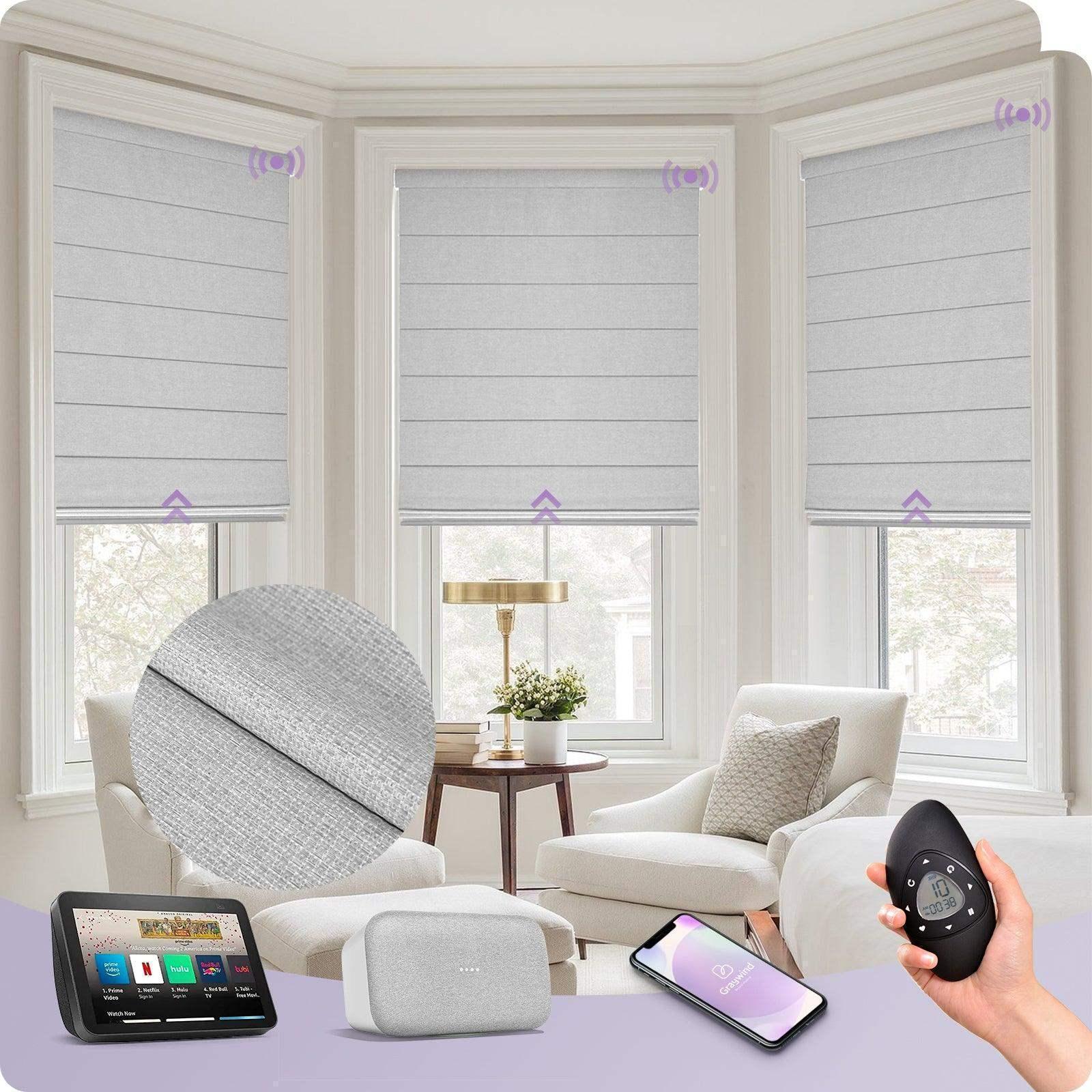 Smart gray motorized window shades in a bright living room, shown with remote control and smart home integration devices.
