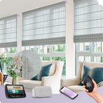Smart gray Roman shades on large windows in a modern living room, controlled by app, remote, and smart home devices.