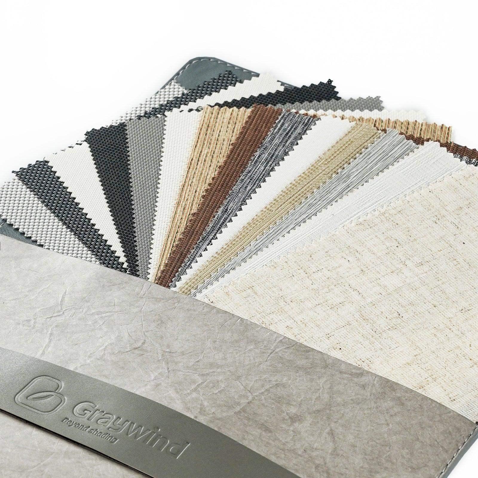 Assorted window treatment fabric swatches in neutral colors on a sample book
