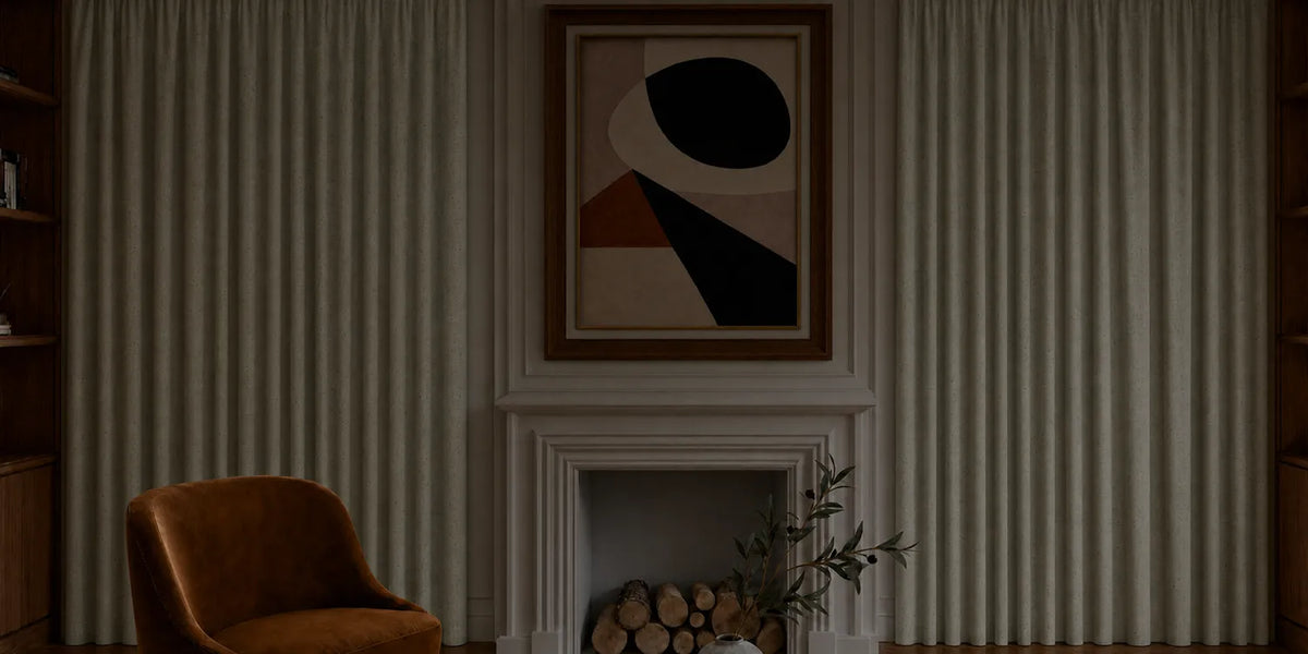 Cozy living room with a brown armchair, abstract art above a fireplace, and striped wallpaper.