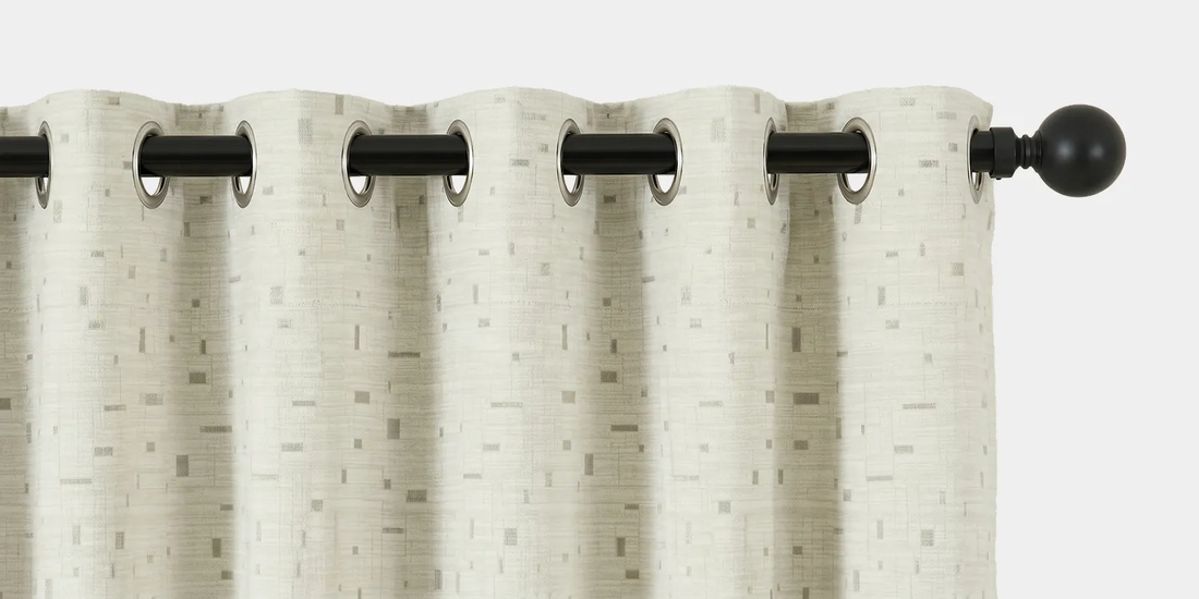 White textured curtain with black grommets on a white background
