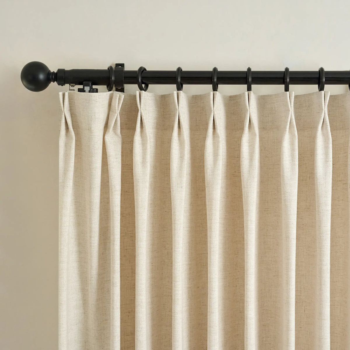 Beige smart curtain with a black rod on a plain background