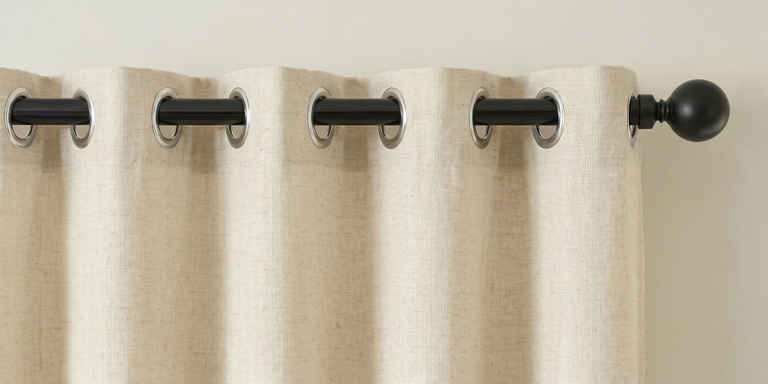 Beige curtains with black grommets and curtain rods on a neutral background