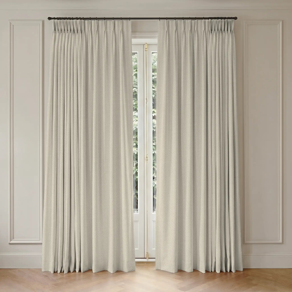 Pair of white curtains with rod hanging in front of a window with light-colored paneled walls.