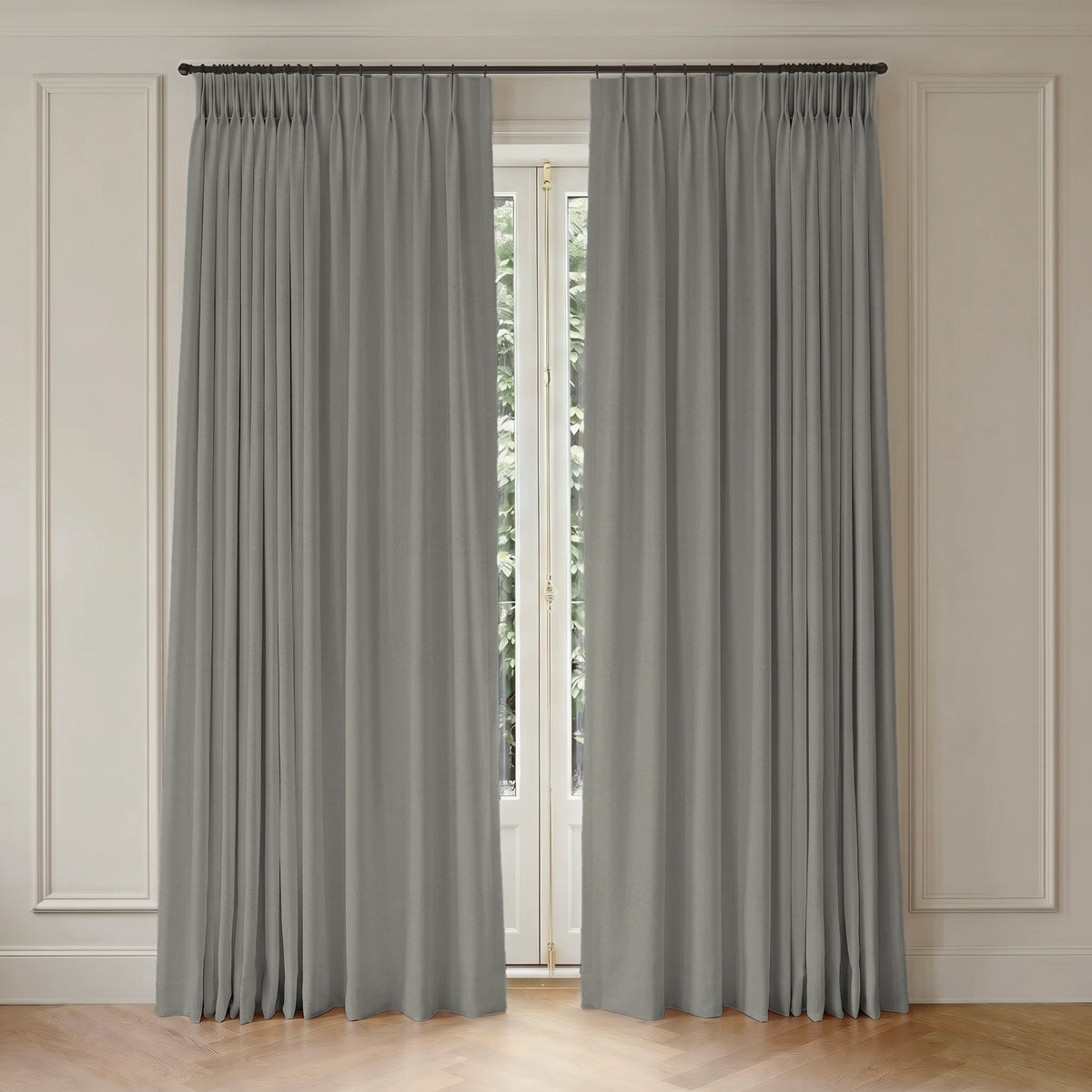 Gray custom curtains hanging in front of a window with light-colored walls.