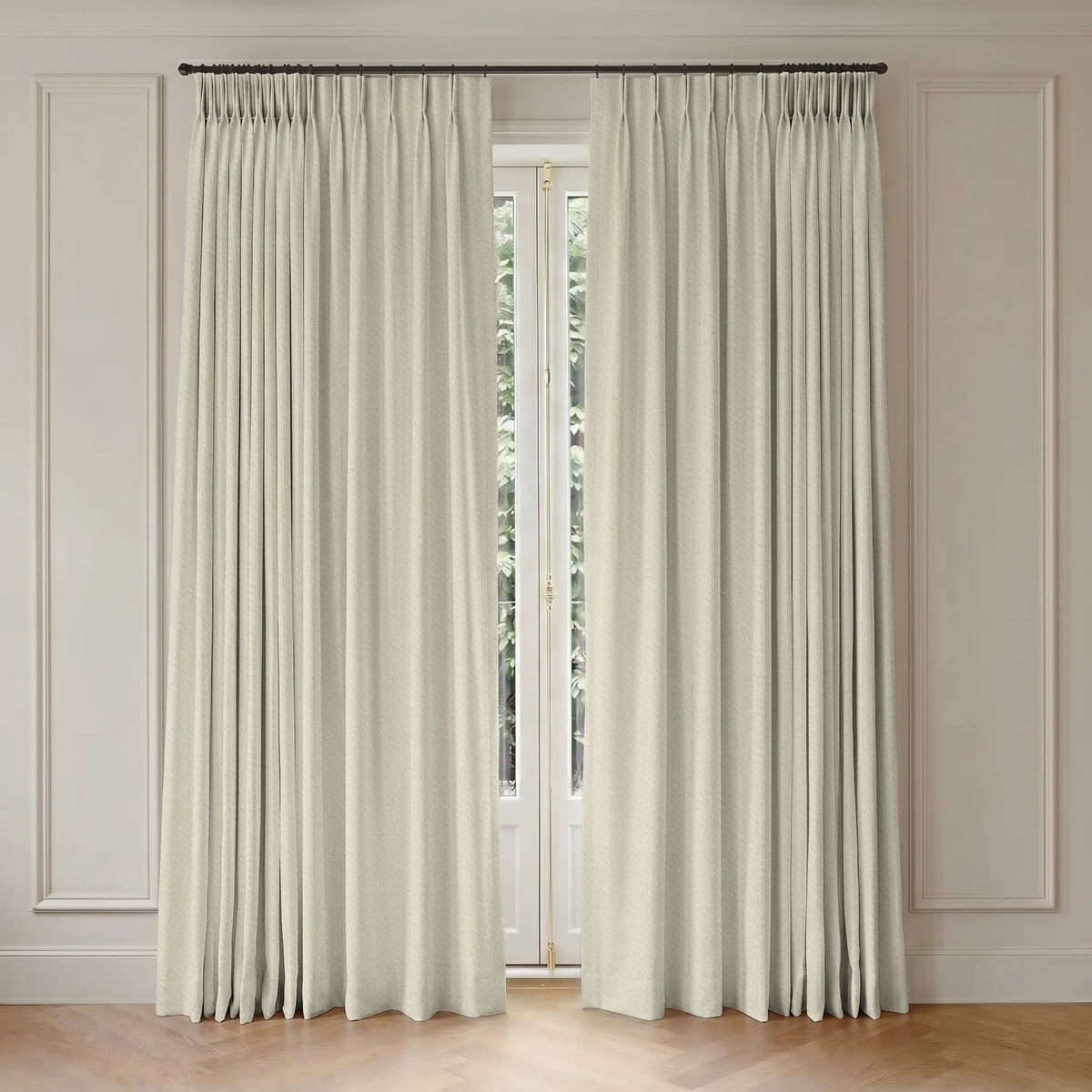 Pair of white curtains with rod hanging in a room with wooden flooring and paneled walls.