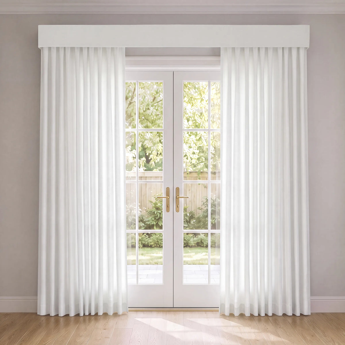 A pair of white sheer curtain panels with a matching white valance hanging on either side of white French doors in a bright room with light wood floors.