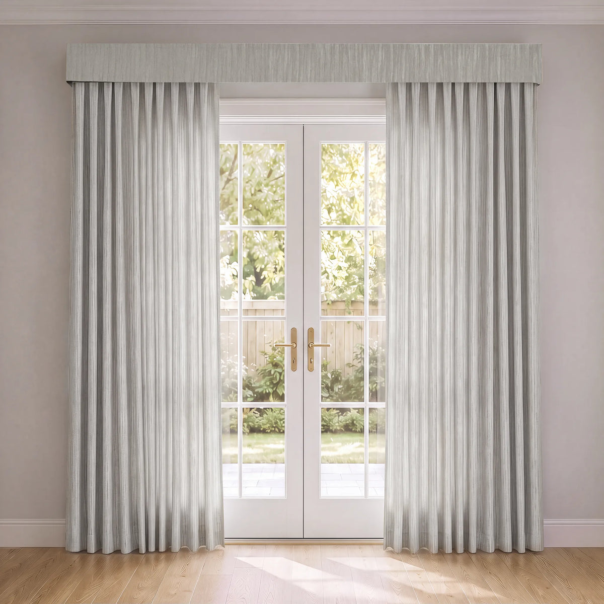 A pair of light gray pleated curtain panels with a matching pleated valance hanging on either side of white French doors in a bright room with light wood floors.