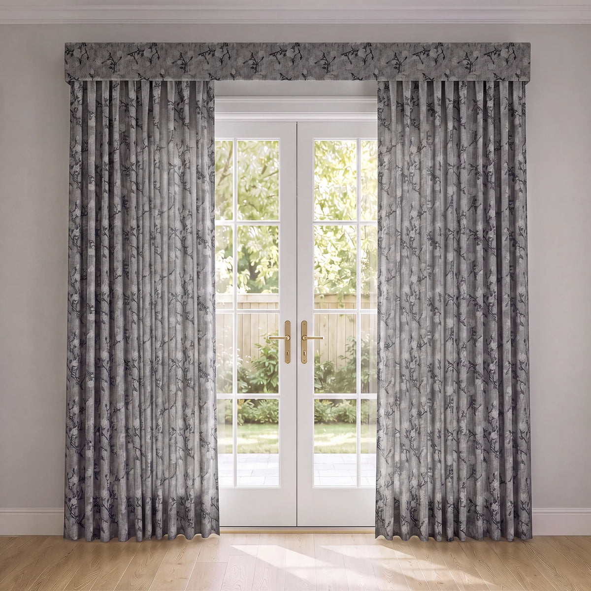 A pair of gray curtains with a dark gray floral pattern, hanging on either side of white French doors in a bright room with light wood floors.