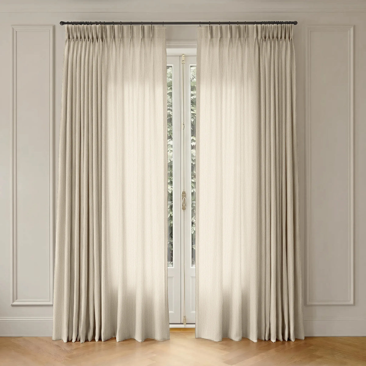 Beige curtains with rod hanging in front of a window with a neutral wall background