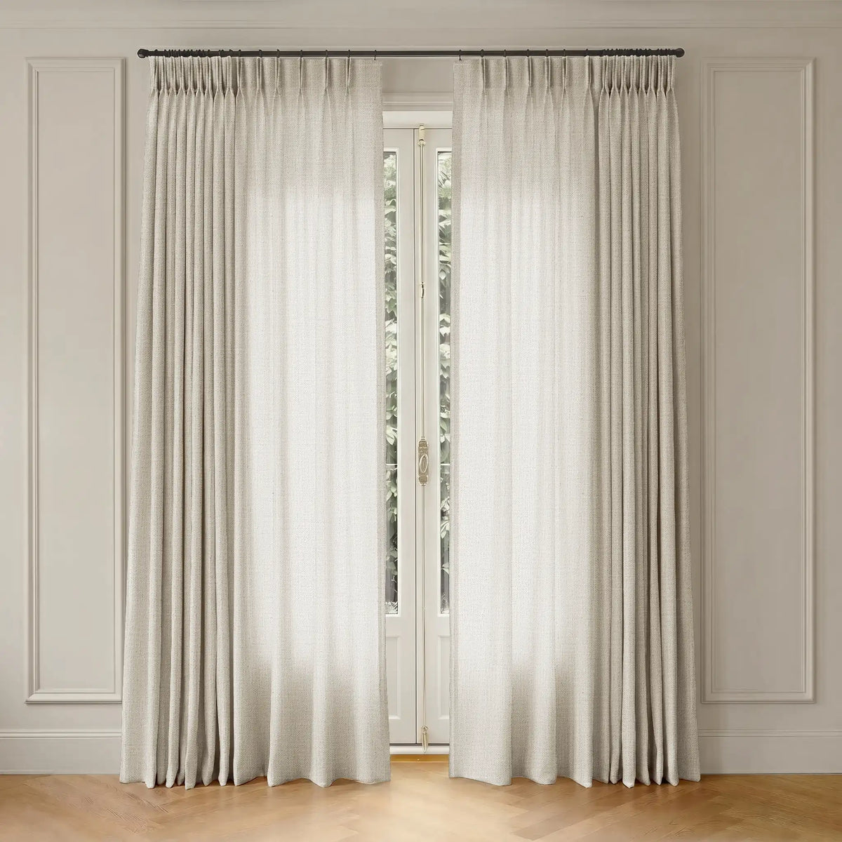 White curtains with rod hanging in front of a window with a neutral wall background