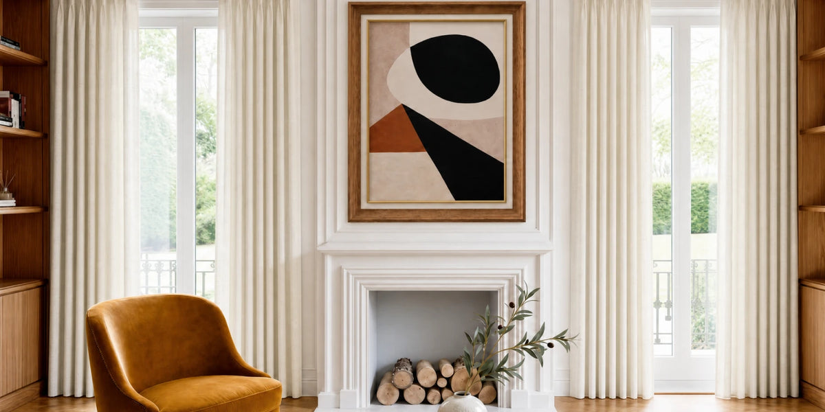 Living room with abstract art above a fireplace, brown chair, and large windows.