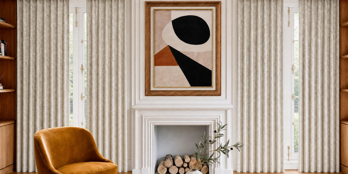 Living room with a brown armchair, abstract art above a fireplace, and striped curtains.