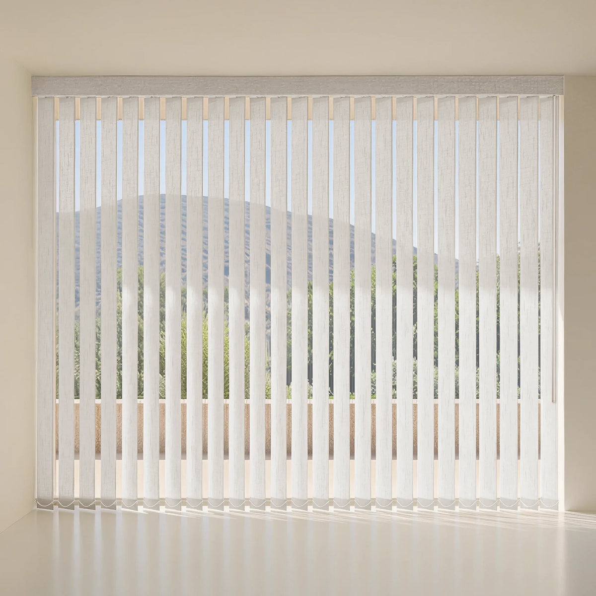White vertical blinds hanging over a window in a minimalist room with beige walls and a light floor.