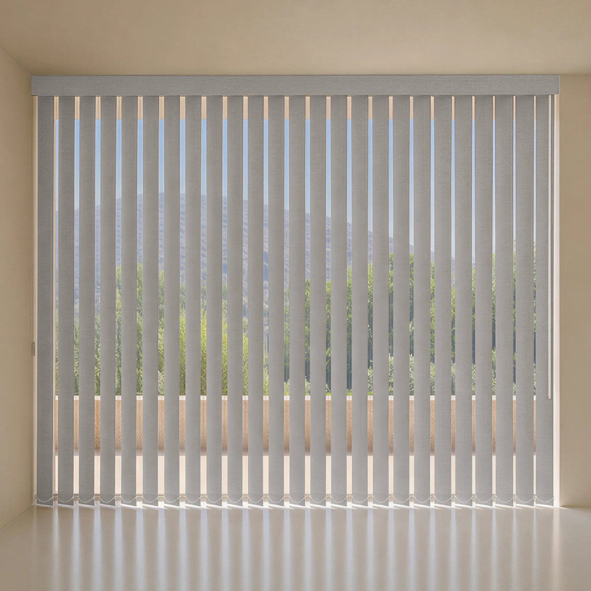 Gray vertical blins installed on a large window, shown in a minimalist room with beige walls and a light-colored floor.