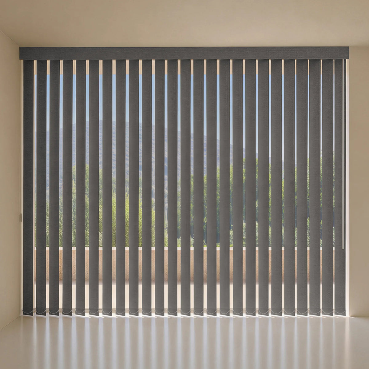 Dark gray vertical blind window treatment installed on a large window, shown from a clean interior perspective with a light-colored floor and beige walls.