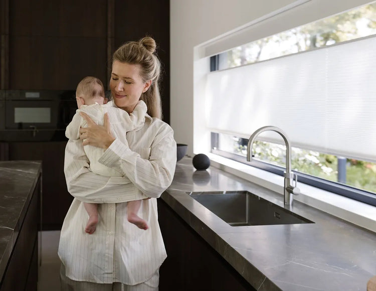 Graywind x Motionblinds motorized top down bottom up cellular shades in a kitchen, offering privacy and natural light for family living.