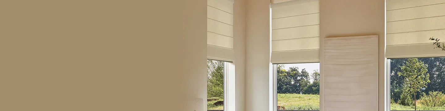 Window with white roman shades in a room with a view of trees