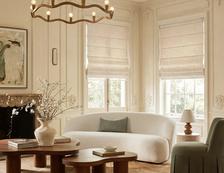 Living room with white sofa, wooden coffee table, and large roman shades.