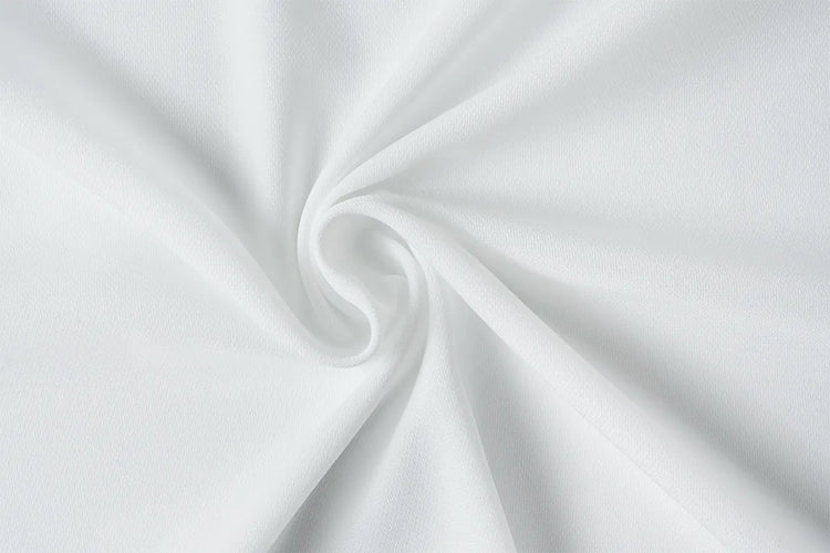 White fabric draped in a spiral swirl pattern, showing a smooth texture and soft shadows.