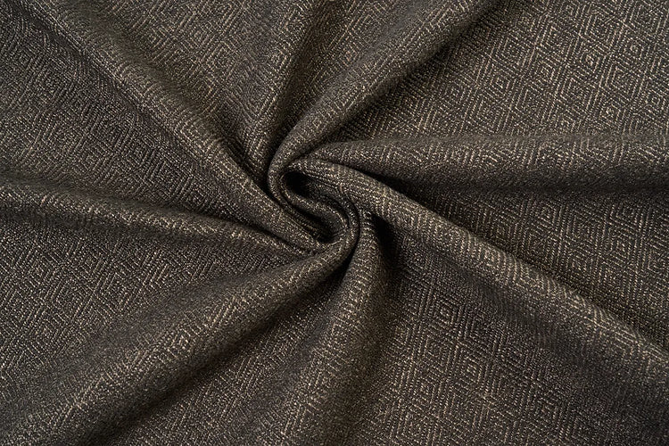 A close-up of dark brown textured fabric with a woven geometric diamond pattern, styled in a central swirl to highlight its texture and drape.