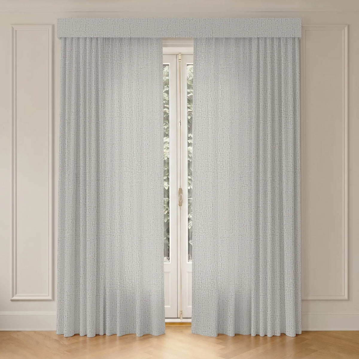 Light gray textured curtain panels with a matching valance hanging in front of a tall window on a white paneled wall with light wood flooring.