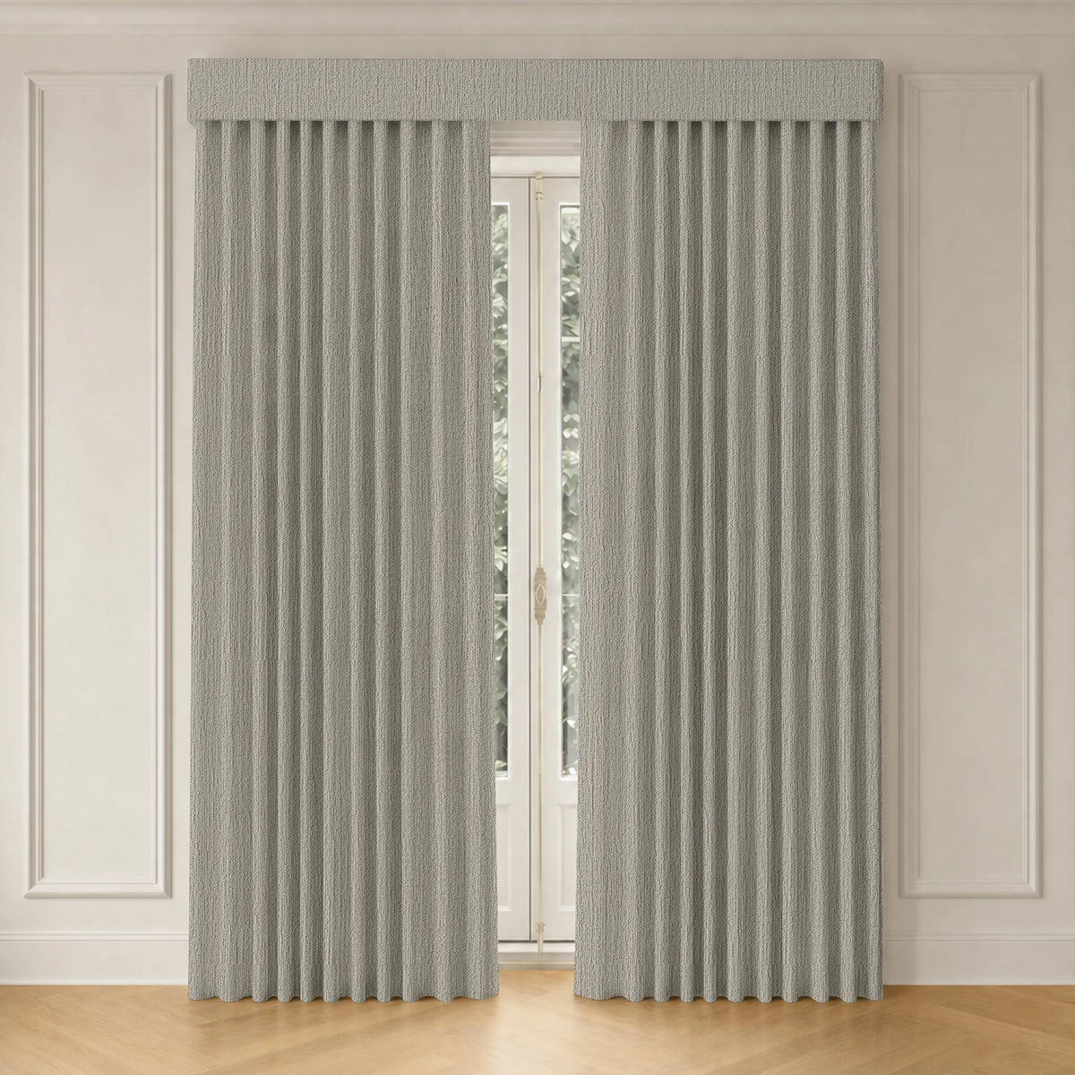 A pair of light gray textured pleated curtains hanging on a window in a room with white paneled walls and a light wood floor.