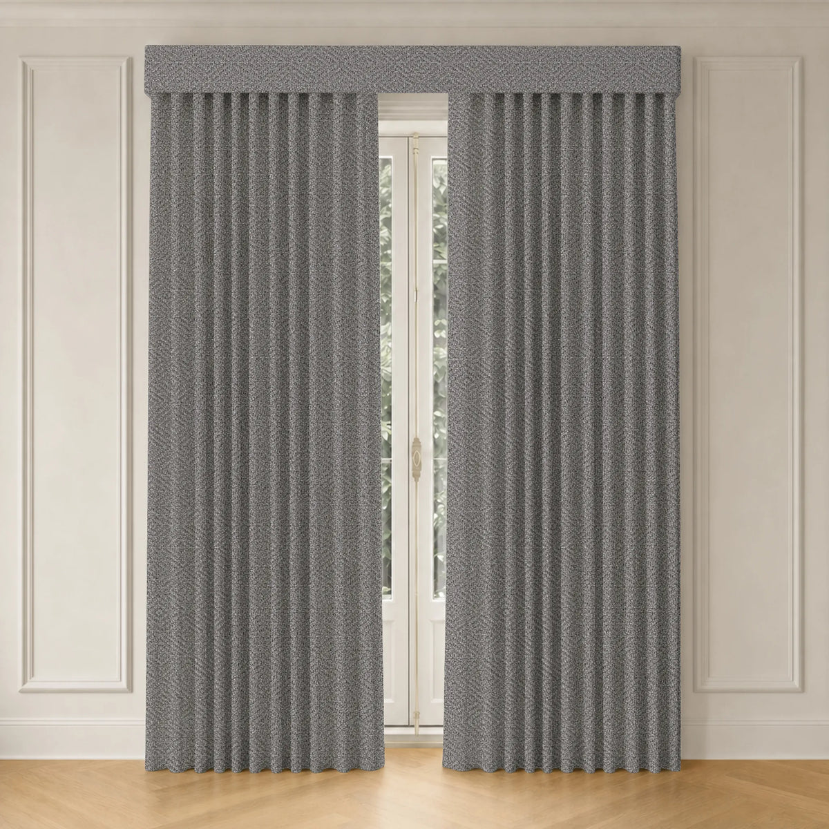 A pair of gray textured pleated curtains hanging on a window in a room with white paneled walls and light wood flooring.