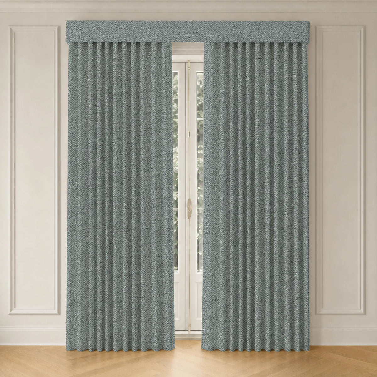A pair of pleated window curtains in a dusty blue-gray color with a subtle textured pattern, hanging on a matching rod against a white paneled wall and light wood floor.
