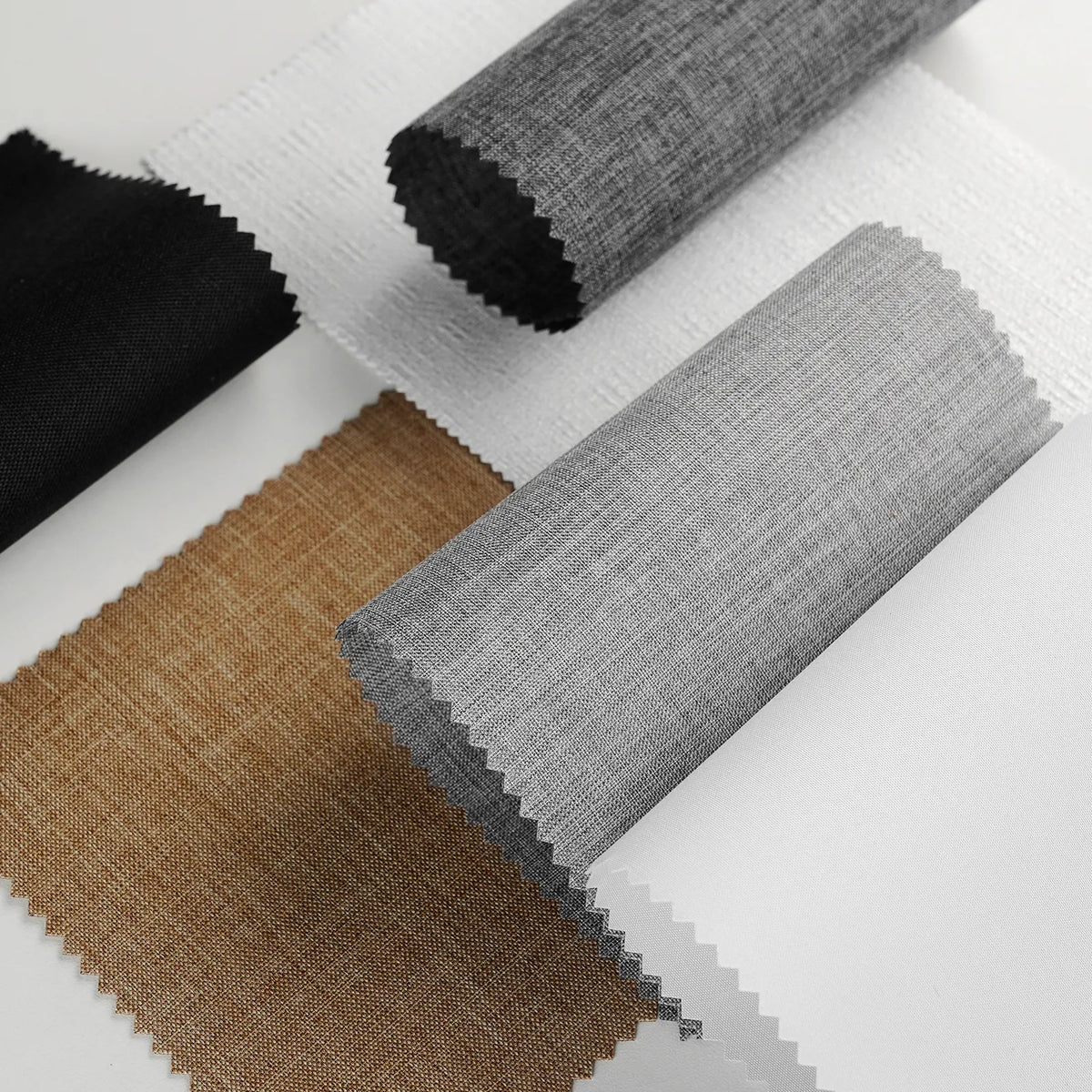 Four fabric swatches with zigzag-cut edges displayed on a white background: black, white, tan/brown, and light gray.