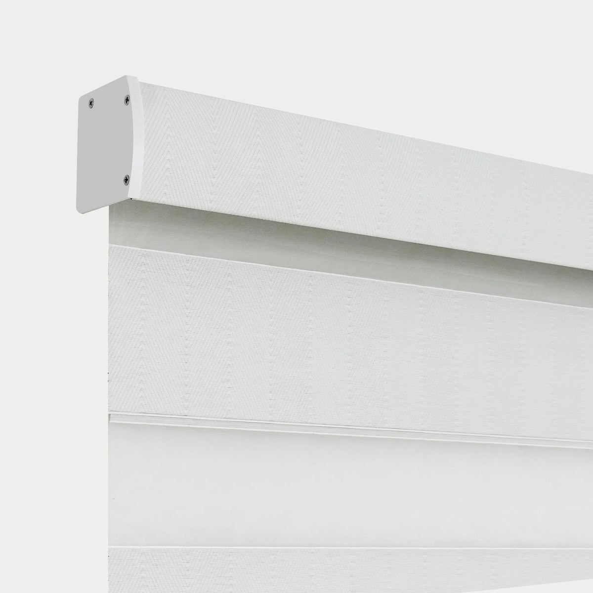 Close-up of a white motorized light-filtering zebra blind with textured alternating fabric bands and a white headrail.