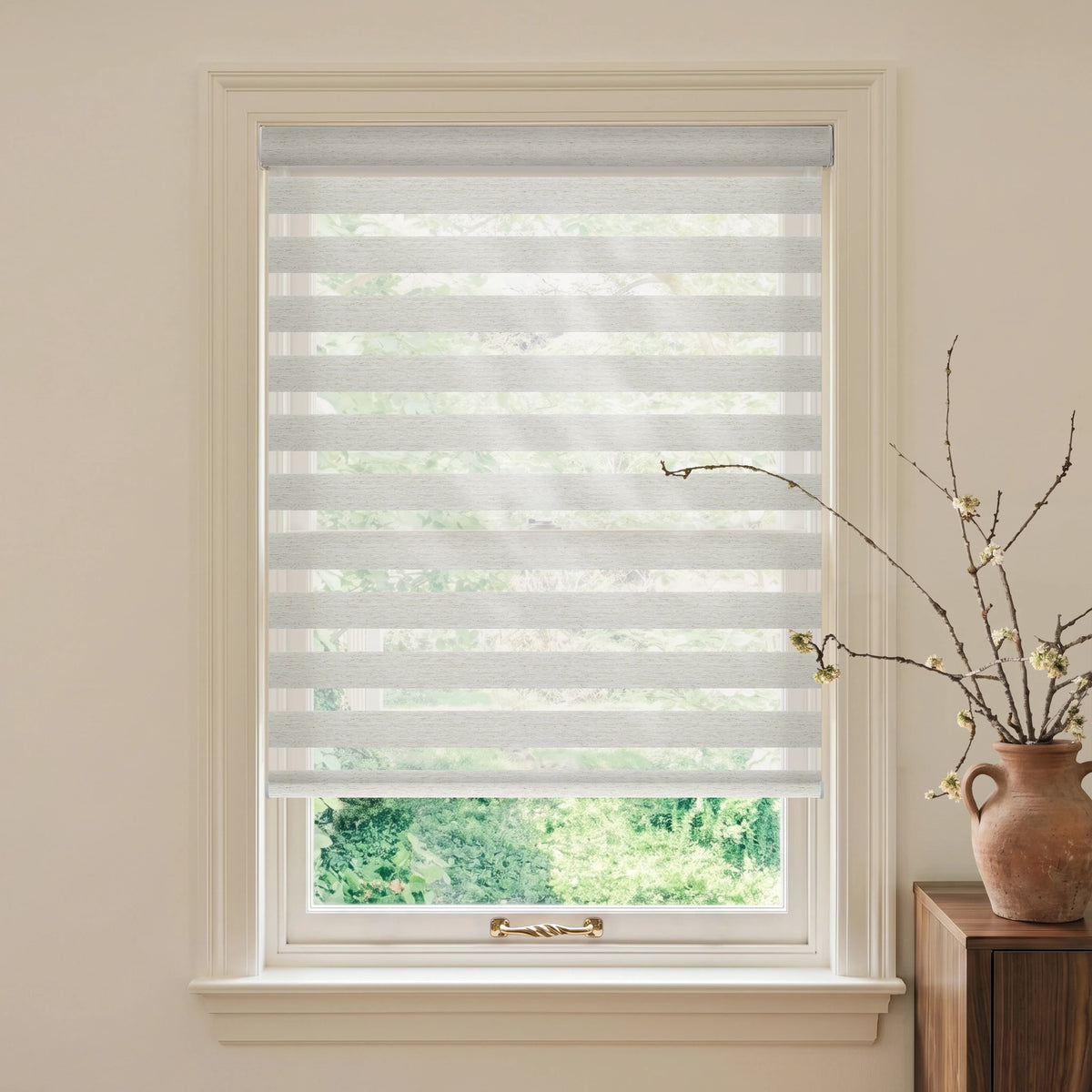 Linen Weave Gray motorized light-filtering zebra blind in a bright room with a terracotta vase and greenery outside.