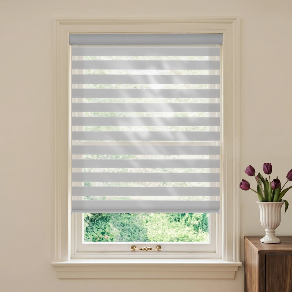 Wool-like Light Grey motorized light-filtering zebra blind in a styled room beside a wooden table and purple tulips.