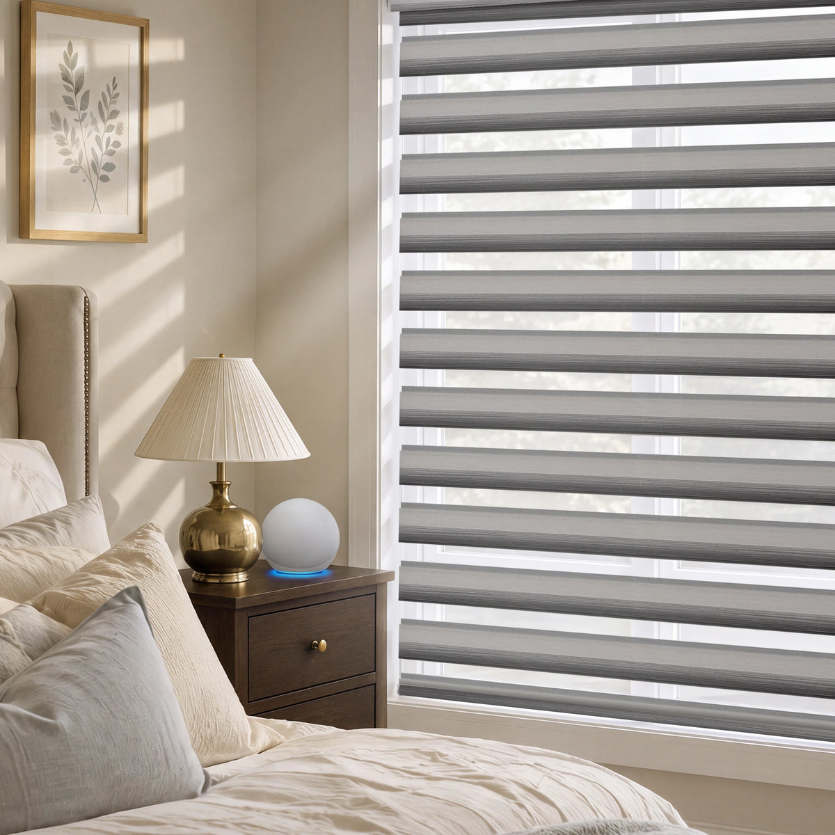 Gray motorized room-darkening zebra blinds installed in a styled bedroom with a bedside table and lamp.