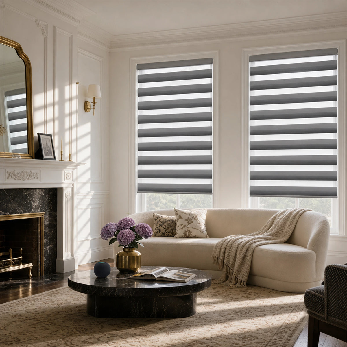 Two gray motorized room-darkening zebra blinds in a modern living room with a cream sofa and dark marble table.