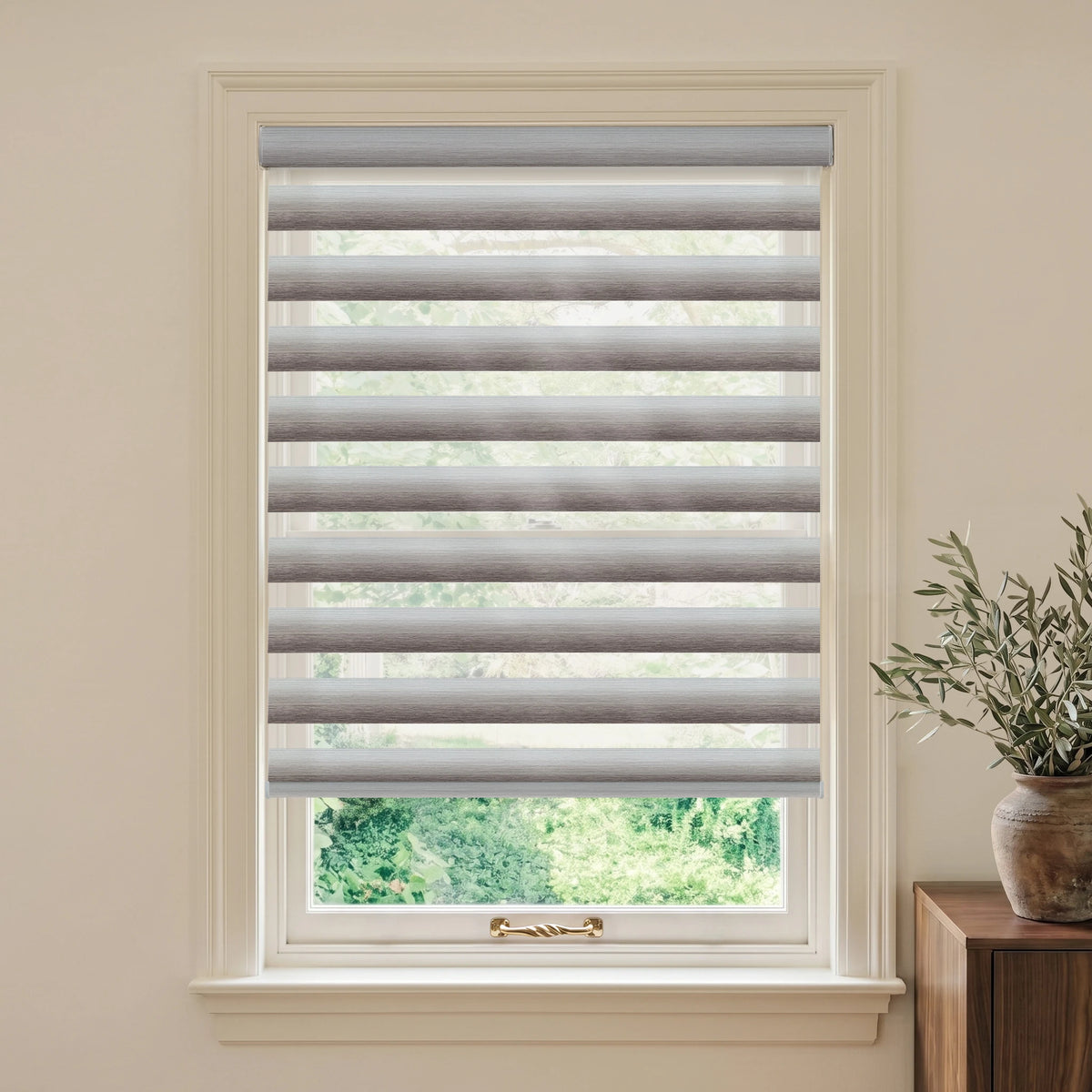 Gradient Brown motorized room-darkening zebra blind in a bright room beside a wooden table and potted plant.