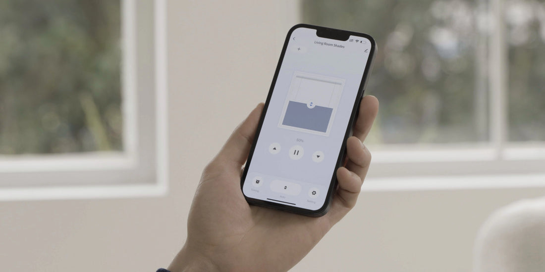 Smartphone app controlling a Graywind manual-motorized roller shade beside a window.