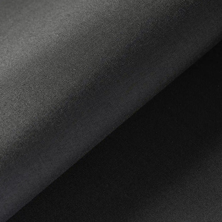 A close-up of dark charcoal gray fabric with a diagonal fold showing the texture and weave.