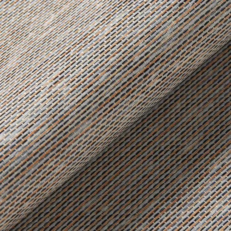 A close-up of woven fabric with a textured diagonal pattern in beige, gray, and brown tones, folded diagonally across the frame.