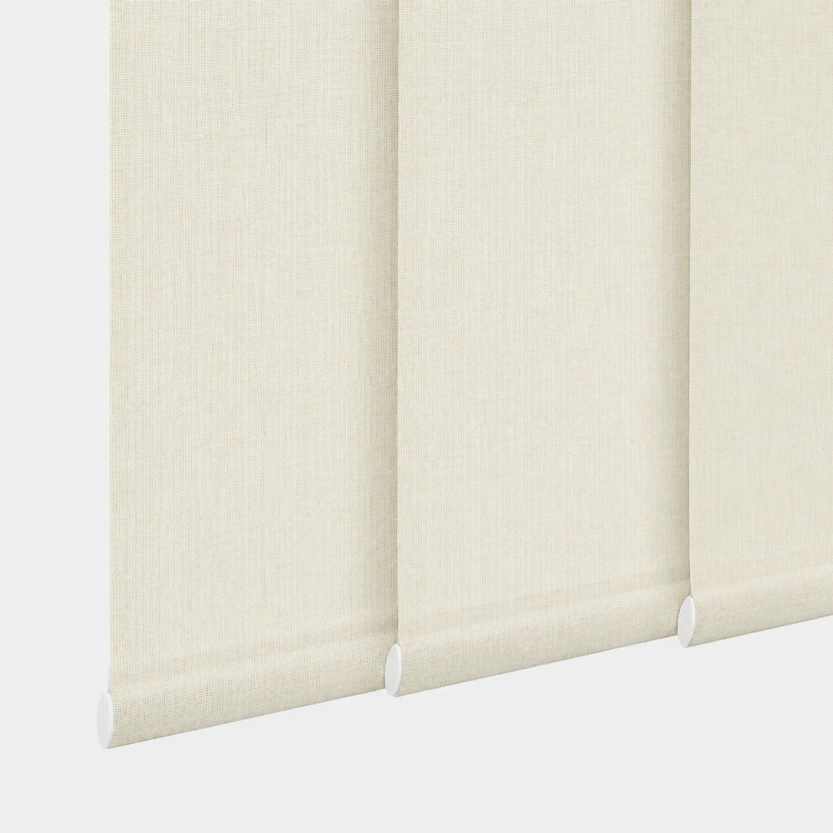 Close-up of a cream-colored roller blind with a textured fabric surface, showing the rolled-up edge and white roller hardware against a light background.