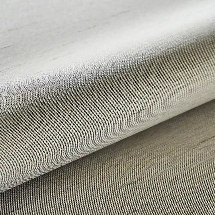 Close-up of beige fabric with a subtle texture on a wooden surface