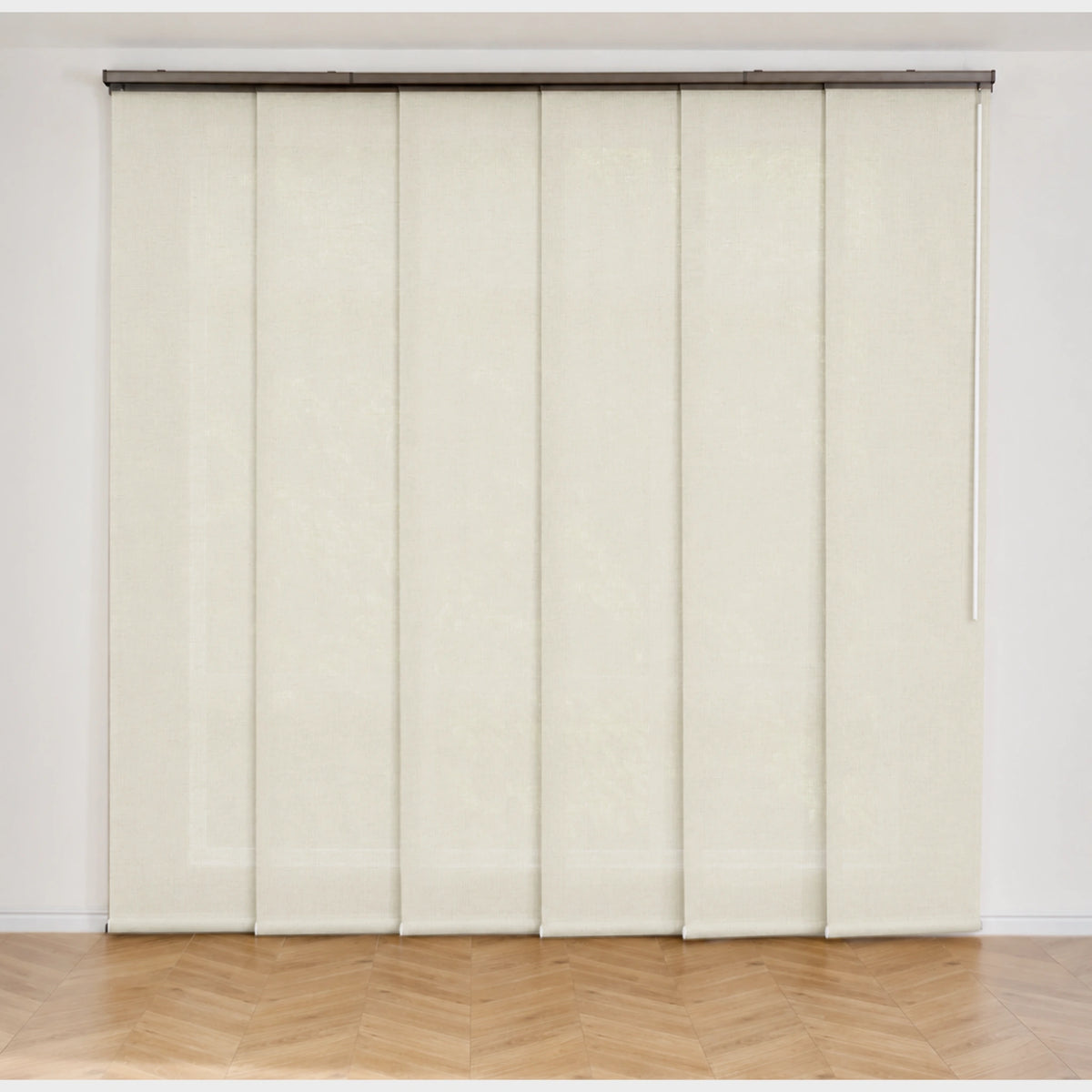 A set of six cream-colored vertical folding panel doors installed on a metal track, set against a white wall with a light wood herringbone floor.
