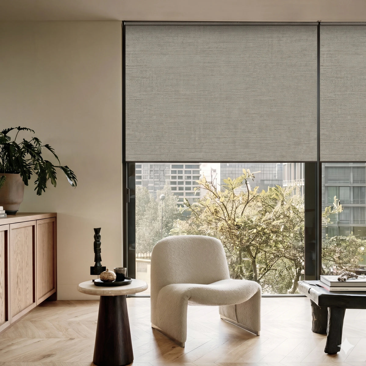 Modern interior with a chair, table, and large window with Graywind x Motionblinds blakcout shades.